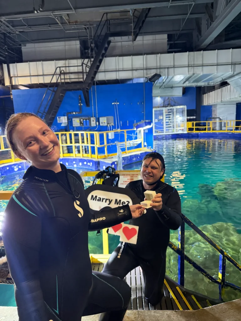 Couple smiling after underwater scuba diving proposal with Haejin Jewelry engagement ring box